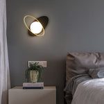 A decorative Galaxy Wall Lamp having a black base and a glowing white orb.