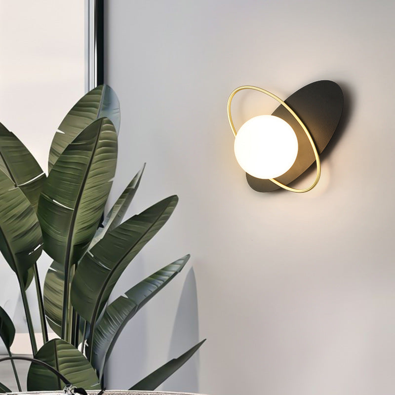 The Galaxy Wall Lamp with an oval backplate and a shiny golden hoop.