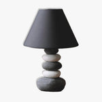 Stacked stone effect table lamp with a black shade for ambient lighting