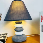 Handcrafted ceramic stone table lamp with a textured base and neutral-toned fabric shade