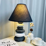 Unique ceramic table lamp mimicking stacked stones, great for home decor.