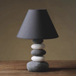 Modern minimalist table lamp featuring a ceramic stone design and warm ambient lighting