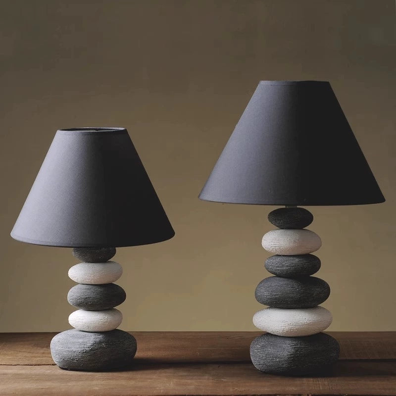 Nature-inspired ceramic lamp with a stone-like base and muted fabric shade for serene spaces.