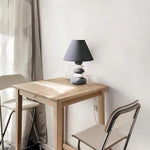 Scandinavian-style ceramic table lamp with a matte stone finish and subtle lighting accents.