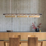 Long pendant light hanging on a wood dining table