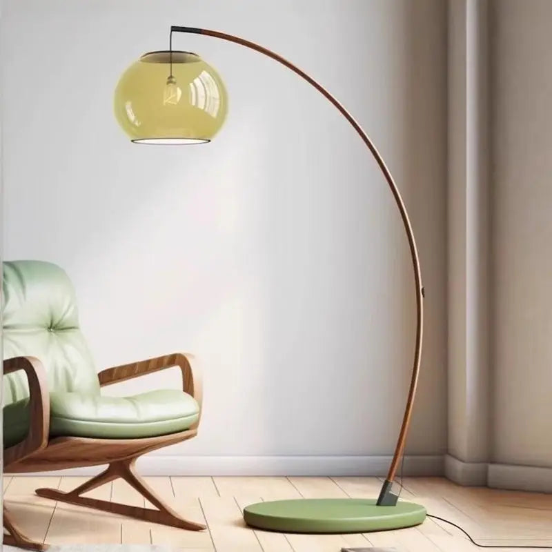 Contemporary Arc Floor Lamp with Glass Shade next to green leather armchair, curved wooden stand for neutral tone living room decor