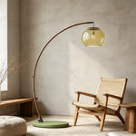 Contemporary Arc Floor Lamp with Glass Shade paired with woven wooden chair, curved arc structure for wabi sabi living room lighting