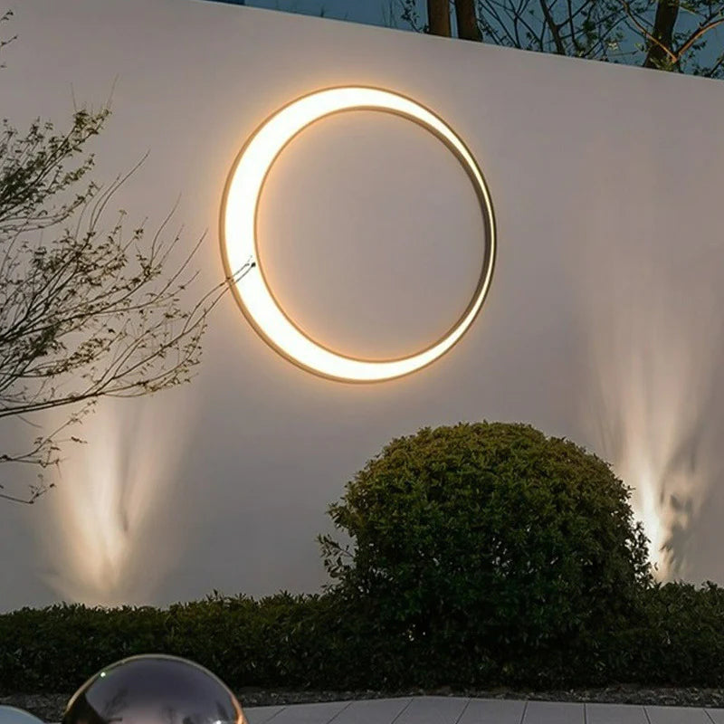 Functional Crescent Wall Light with a glowing circle on textured wall