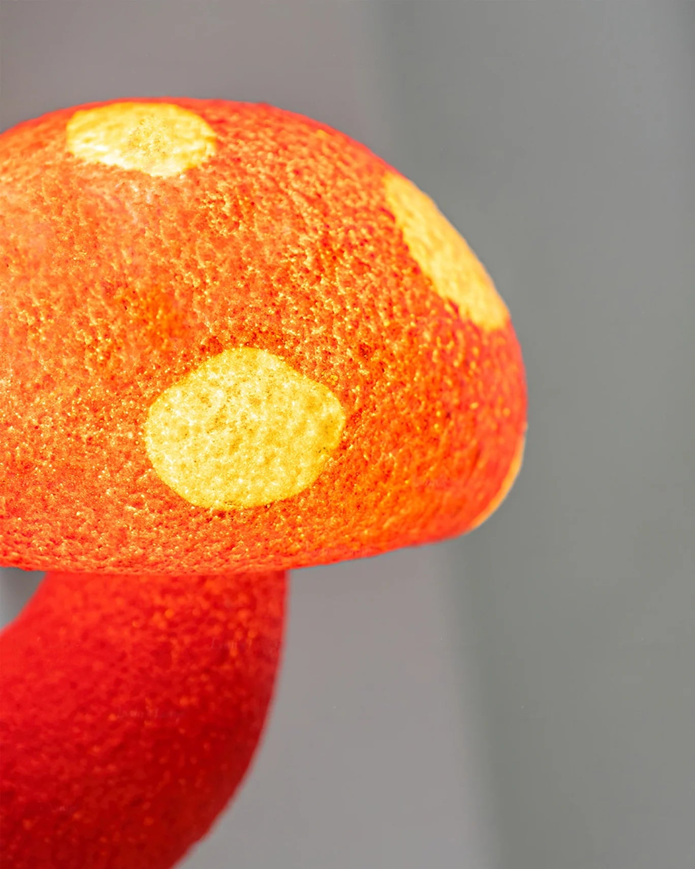 Close up of the red mushroom wall sconce emitting warm and cozy light