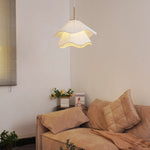 Living room with a beige sofa, decorative pillows, and a hanging lamp.