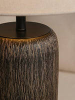 The junction between the top of the fabric lampshade and the lamp pole.
