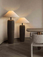 Two fabric shade floor lamps next to the dining table