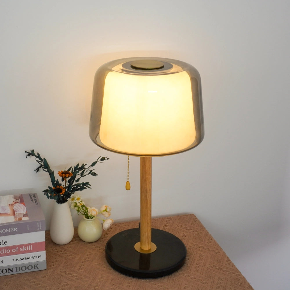 Smoked grey table lamp and several books on the desk