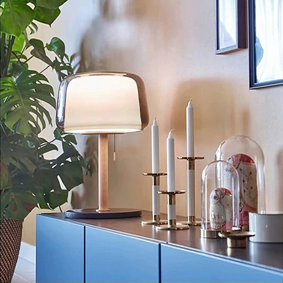 The designer table lamp placed on the cabinet emits a warm light