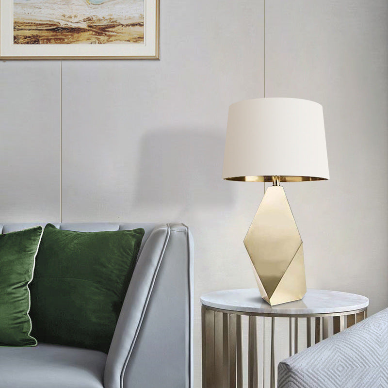 A modern table lamp with a Facted lamp column is next to the sofa