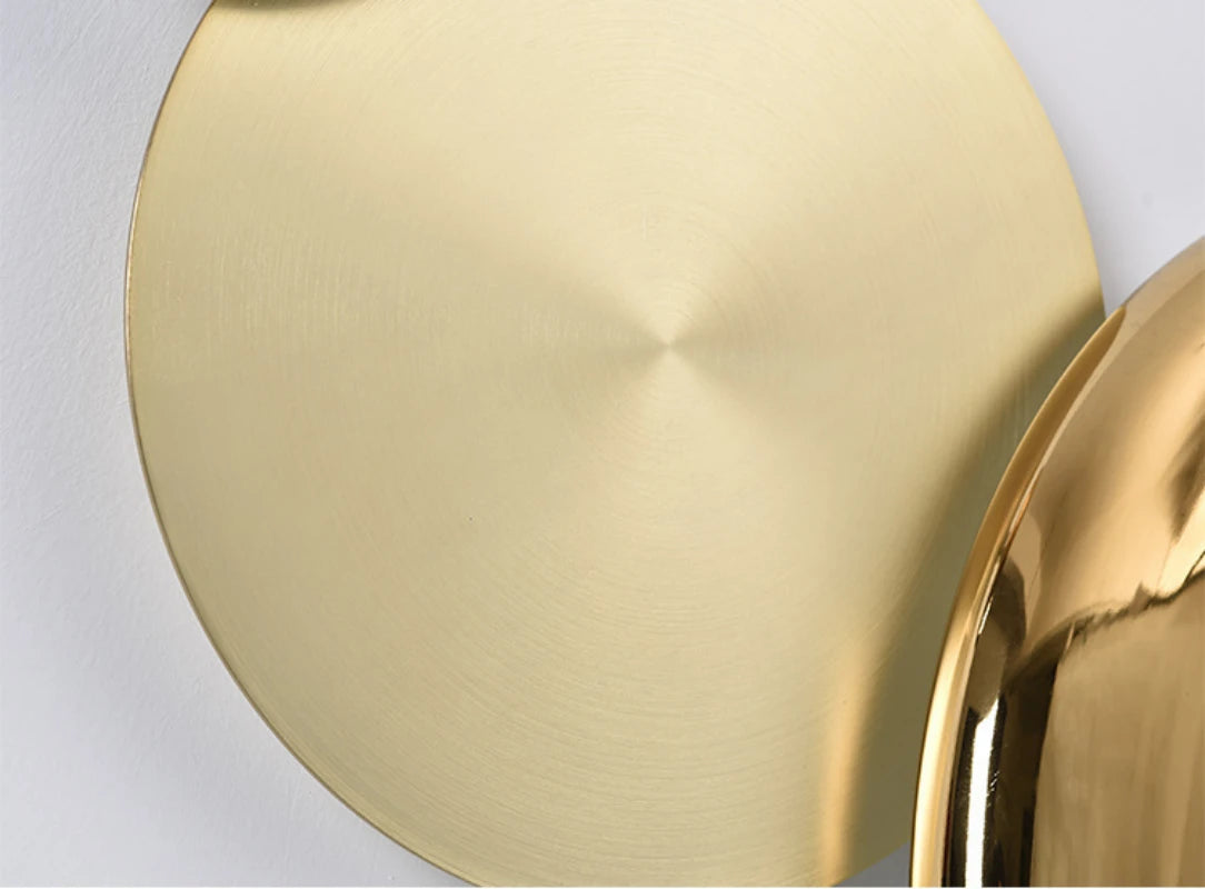 Detail of the metal disc of the golden wall lamp