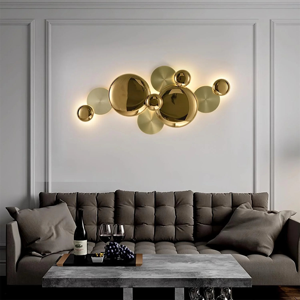 Golden wall lamp casting warm ambient light above a contemporary sofa