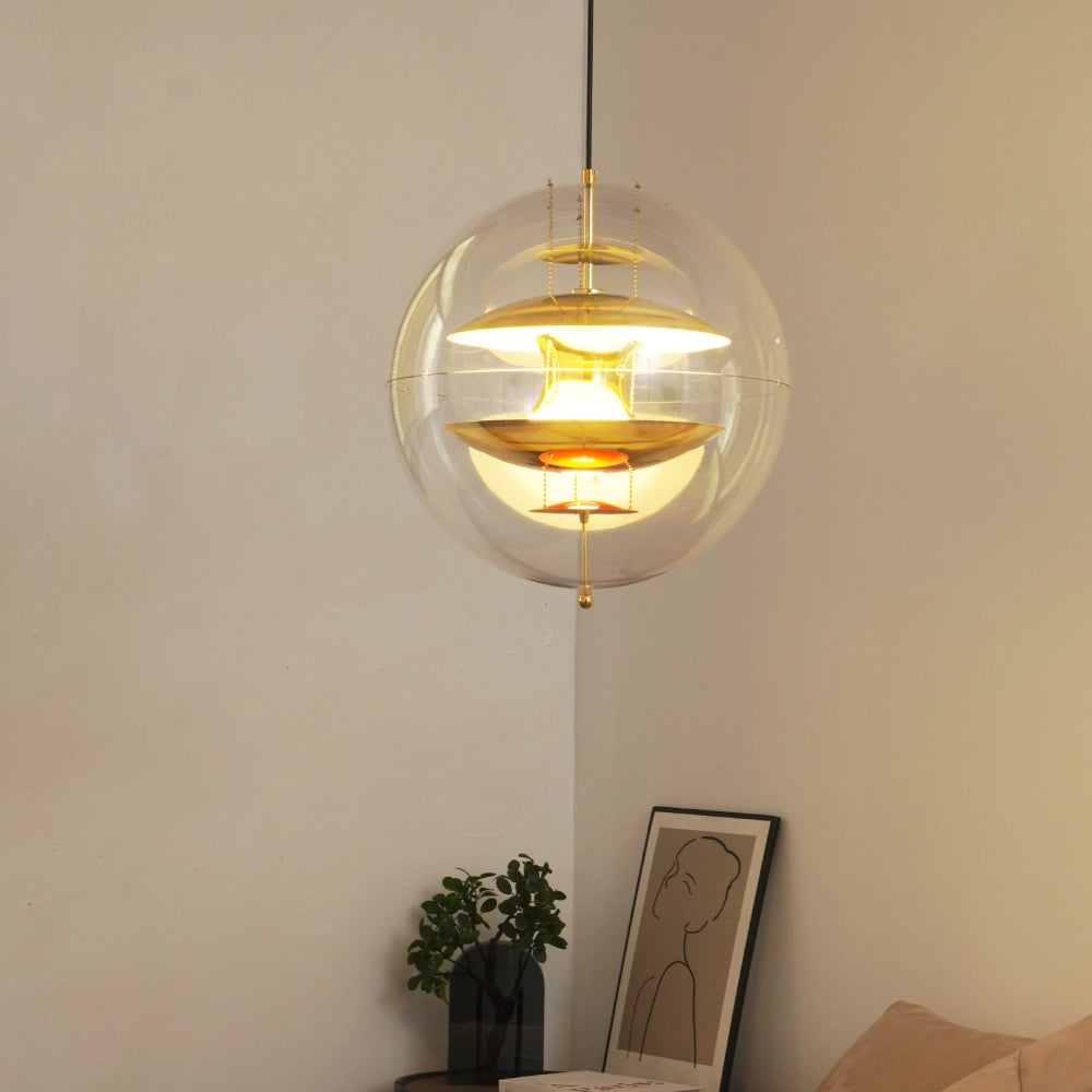Modern pendant light with clear glass shade and gold interior in a room setting.