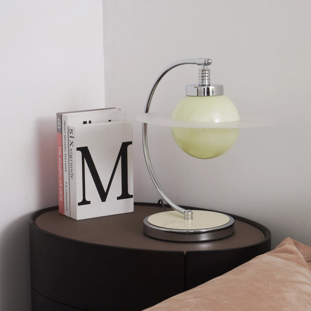 Planet-inspired table lamp with translucent green glass sphere and circular disc, modern bedside light with chrome frame