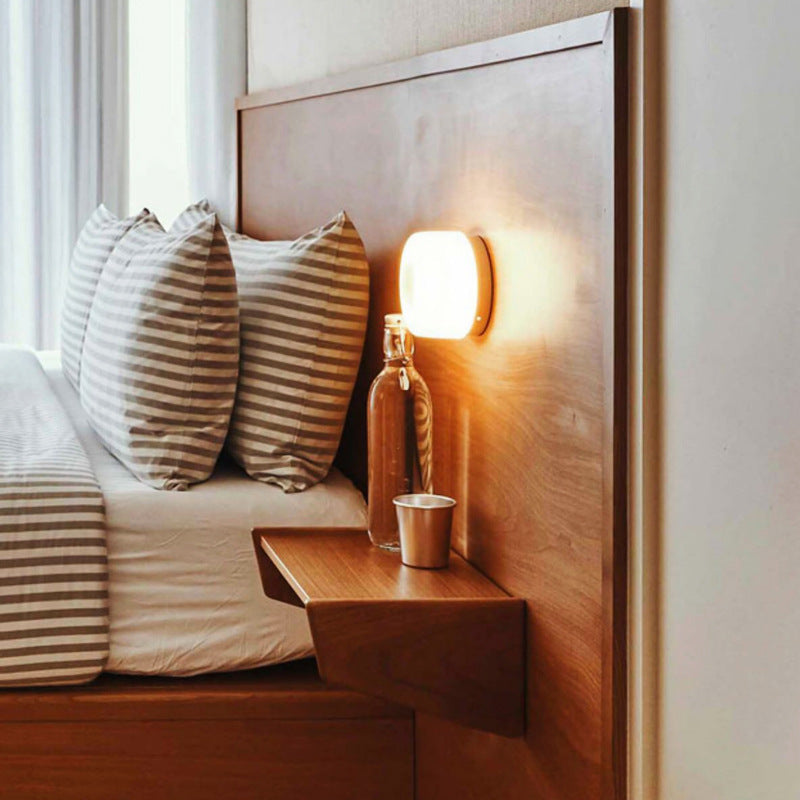 white wall lamp next to the bed