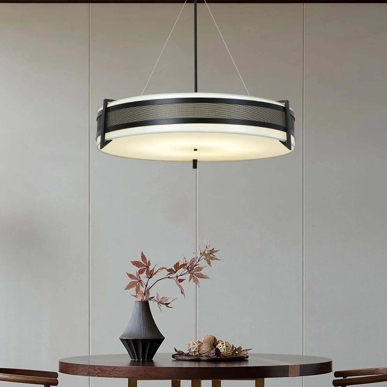Stylish Fabric Circle Chandelier hanging above a modern dining table with decorative vase and leaves.