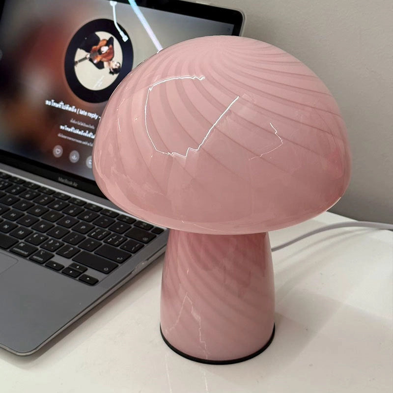 Pink mushroom-shaped lamp on a desk next to a laptop