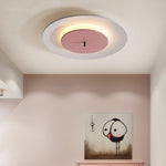 Looking up, there is a round ceiling lamp on the ceiling. The white outer ring matches the pink part in the middle harmoniously, and the warm light shines through the edge.