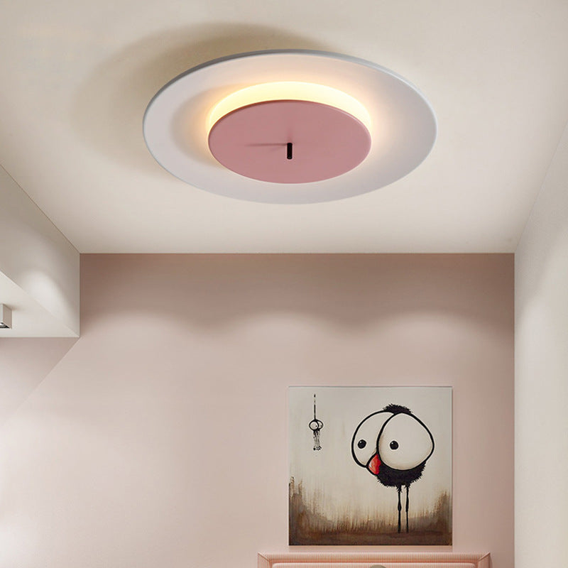 Looking up, there is a round ceiling lamp on the ceiling. The white outer ring matches the pink part in the middle harmoniously, and the warm light shines through the edge.