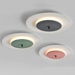 Three modern ceiling lights are installed on the gray ceiling, with white outer rings and gray, green and pink centers.