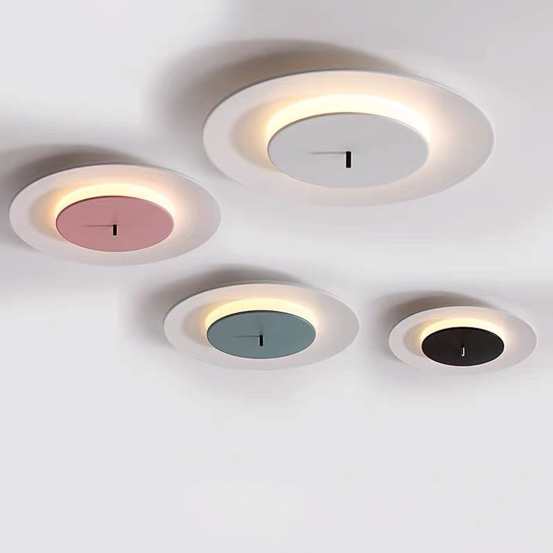 Four round ceiling lights are installed on the white ceiling, with a white outer ring and a central area of ​​different colors such as pink, gray, blue and black.