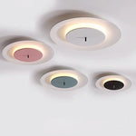 Four round ceiling lights are installed on the white ceiling, with a white outer ring and a central area of ​​different colors such as pink, gray, blue and black.