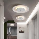 On the ceiling of the corridor, three white round ceiling lamps are arranged in a row, emitting warm light at the edges.