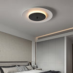 In the bedroom, a lamp with a white outer ring and a black middle area contrasts sharply with the warm yellow halo.