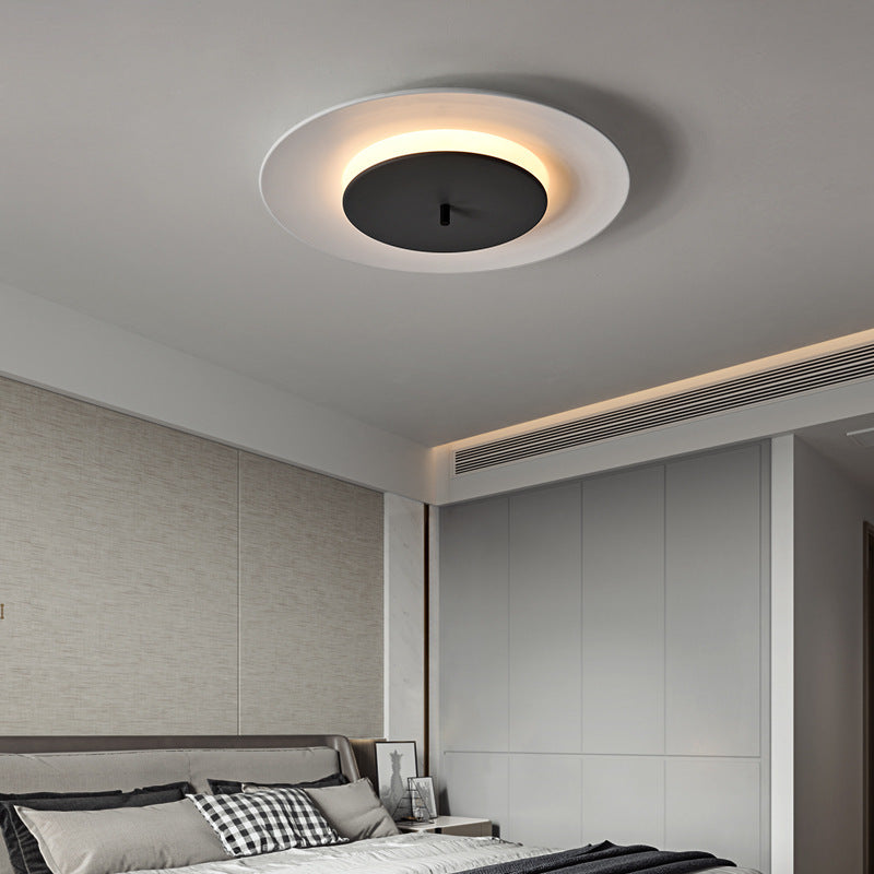In the bedroom, a lamp with a white outer ring and a black middle area contrasts sharply with the warm yellow halo.