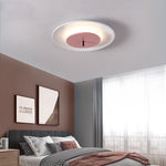 When you step into this bedroom, you will see the round ceiling lamp on the ceiling. It has a white outer circle and a pink area in the middle.