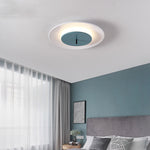 This bedroom presents a simple and comfortable style. On the ceiling, the circular ceiling lamp has a unique design, with a white outer ring and a blue-green area in the middle.