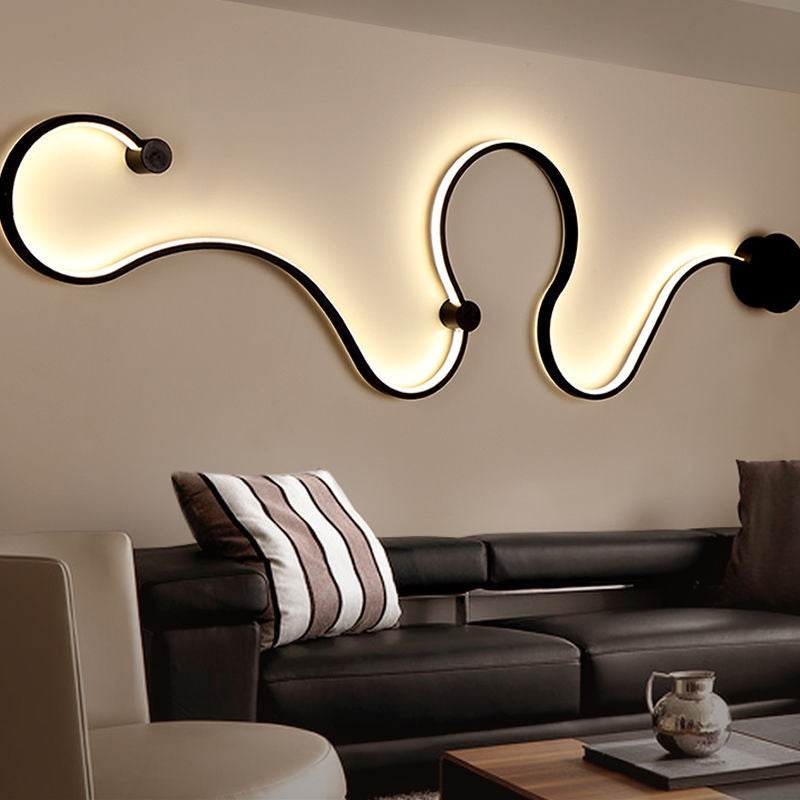 Black silicone snake-shaped sconce paired with exposed pipes and leather furniture for urban chic.