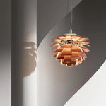 The rose gold pine cone pendant light casts shadows on the load-bearing column