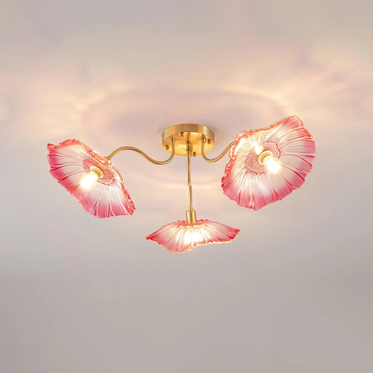 Three headed ceiling lamp with gold bracket and pink petal shaped glass lampshade