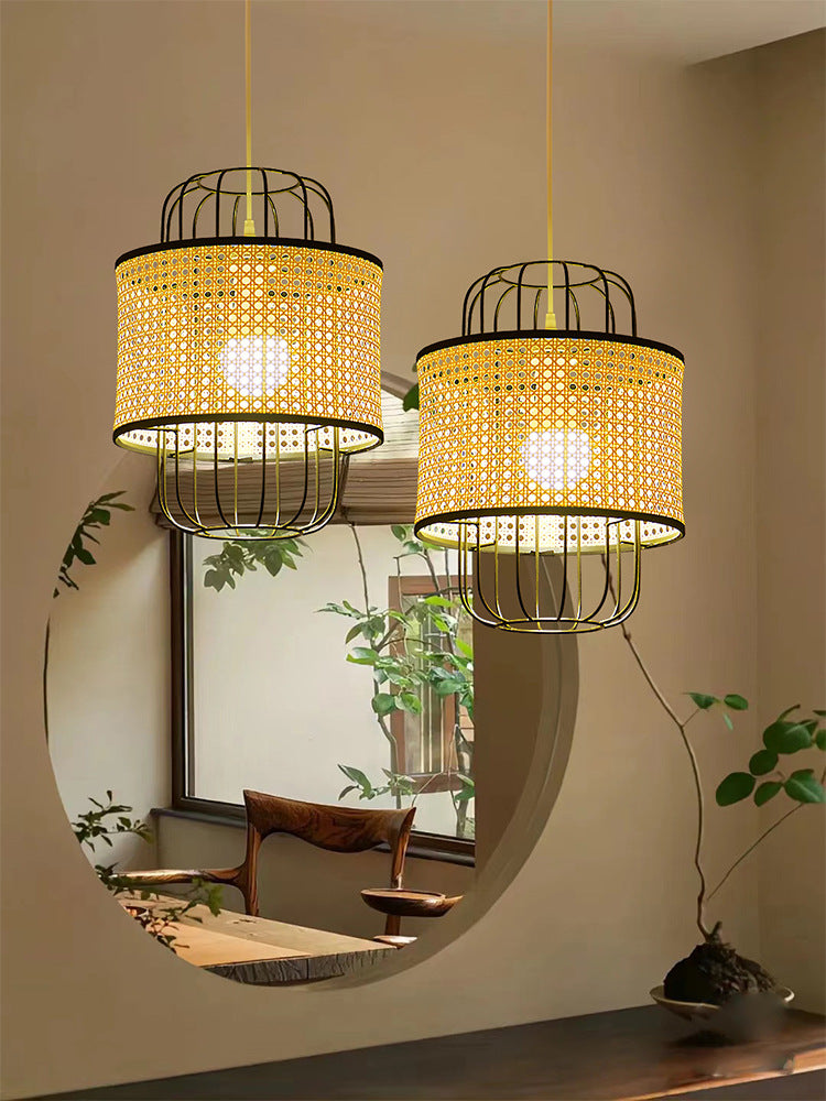 Adjustable rattan pendant light with a black metal chain, perfect for kitchen islands or entryways.