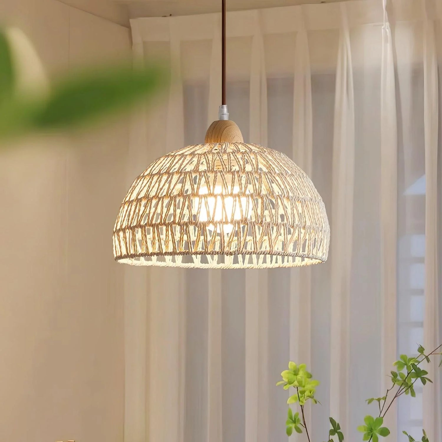 Modern Woven Pendant Light hangs in a bedroom with sheer curtains, casting warm light through the woven shade