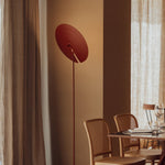 Modern home floor lamp with a unique circular shade, offering soft light for reading or relaxing.