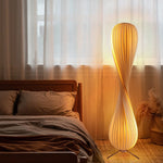 Rolled_Edge_Floor_Lamp_Features_a_spiral_design_with_striped_shades_casting_warm_light.
