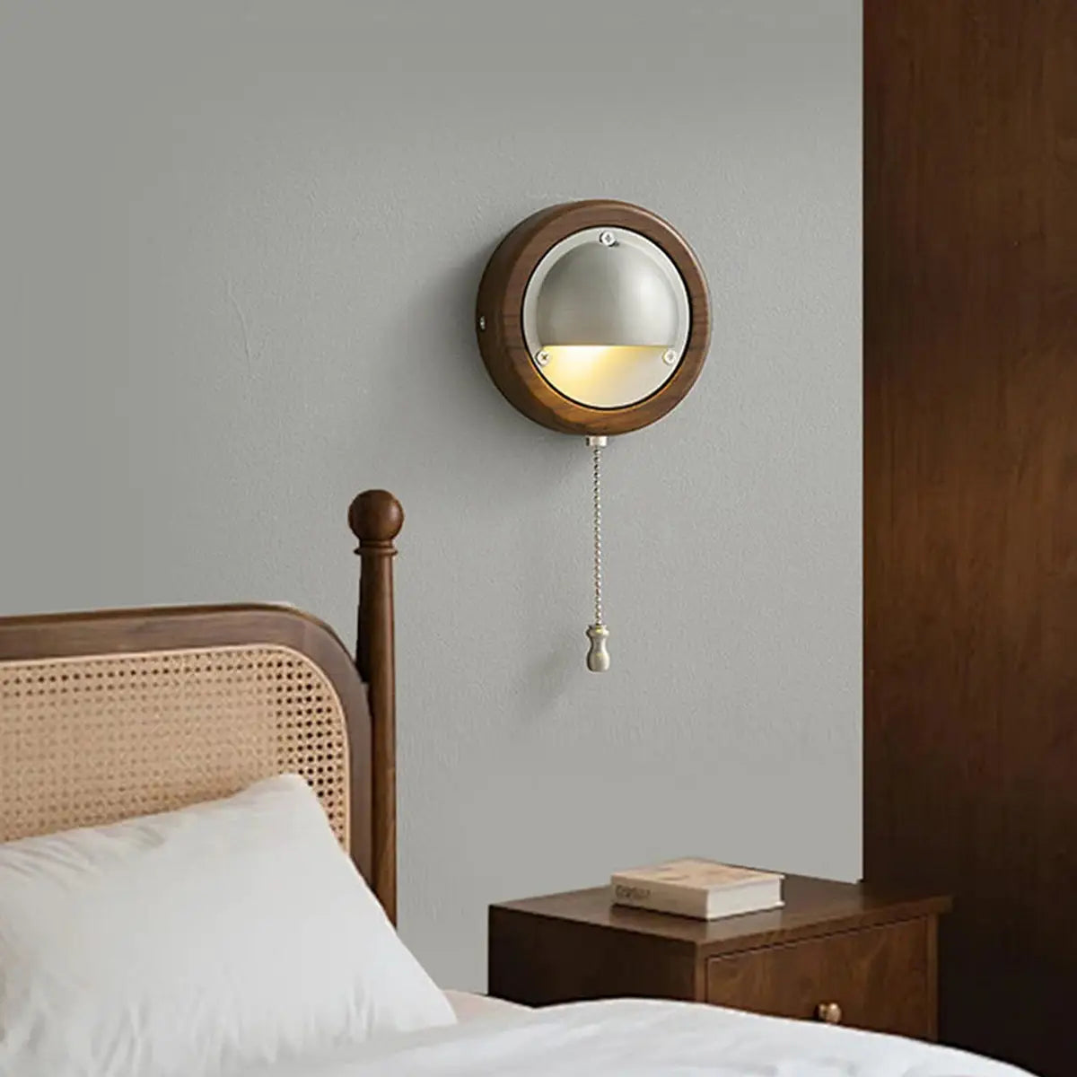 Round walnut frame forms the classic outer shell of Voss Wall Lamp for bedroom walls