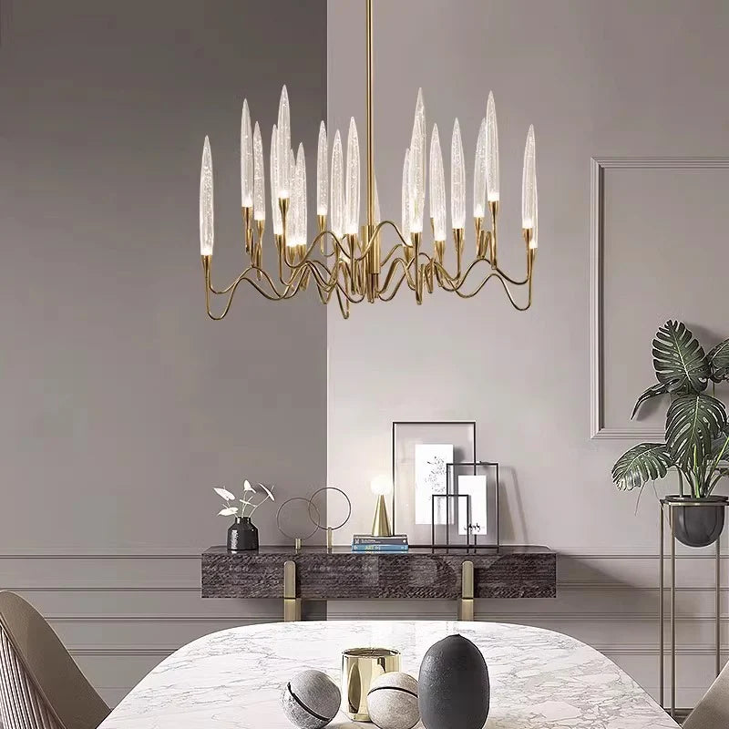 Serenova Chandelier linear gold metal chandelier with bubble glass tubes mounted above marble round dining table in modern residential dining room