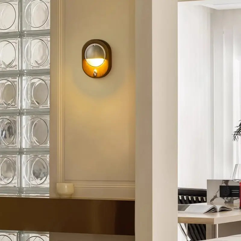 Textured glass‑block wall balances warm illumination from single Voss Wall Lamp