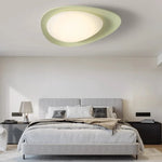 Green curved ceiling lamp with smooth lines, adding modern elegance to spaces.