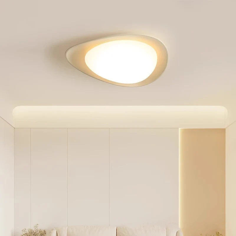 Unique-shaped ceiling light in white, casting soft glow while enhancing room charm.