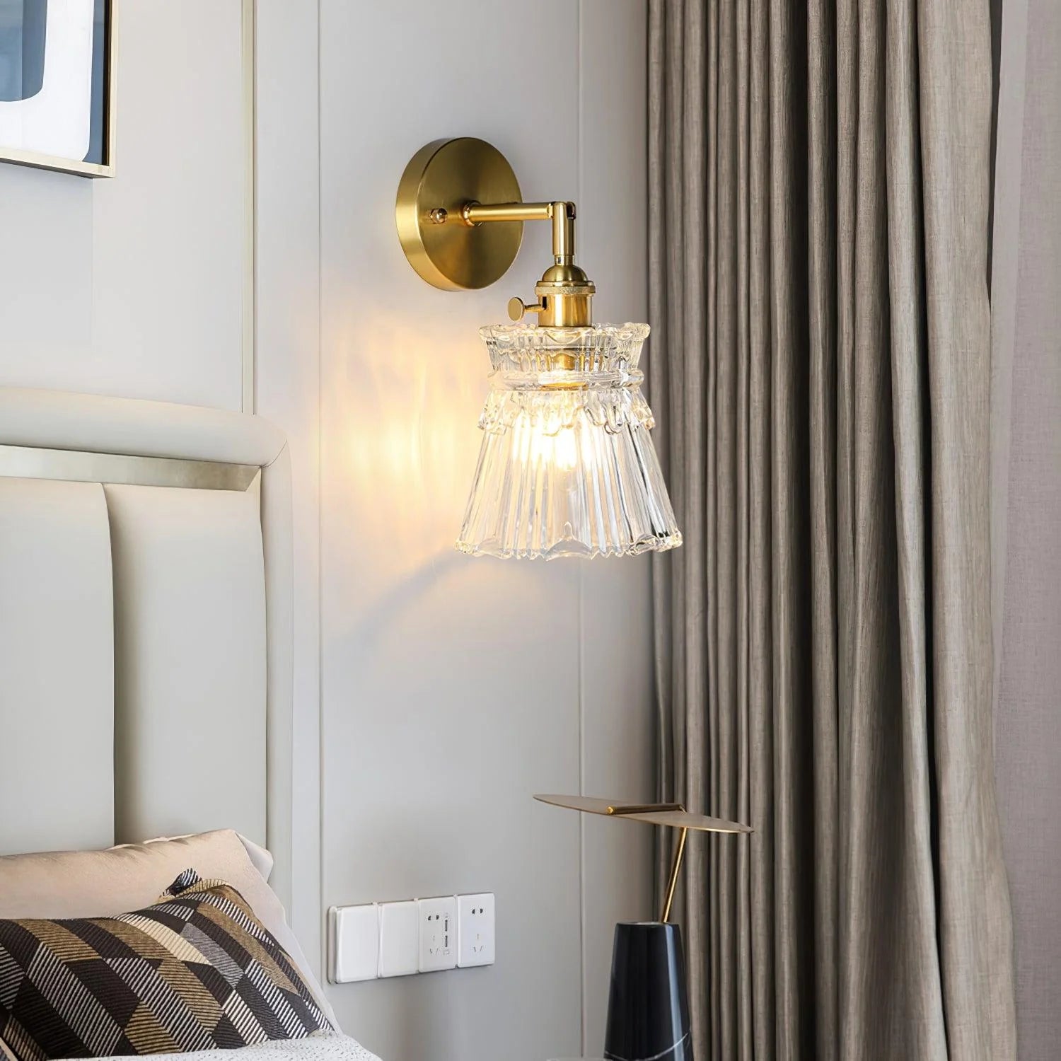 transparent glass wall lamp next to upholstered bed headboard and linen curtain, modern vintage bedroom decor