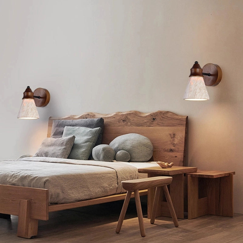 Travertine Wabi-sabi Wall Lamps: Pair of wood-base lights with textured travertine shades, casting soft glow above a natural wood bedroom bed (wabi-sabi aesthetic).